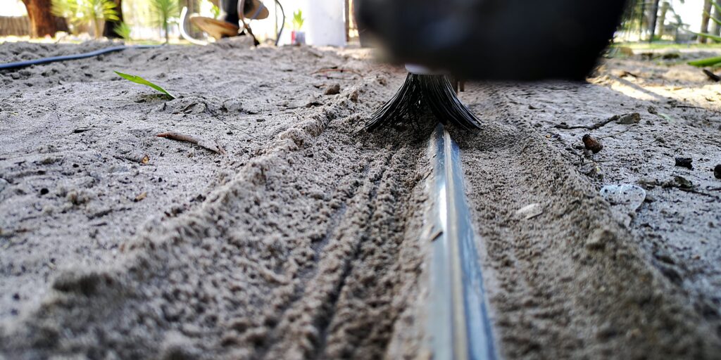 Sliding gate track close-up with Mr. Sweepie® brush kit - for steep driveways where debris washes down, we recommend two sets per gate.