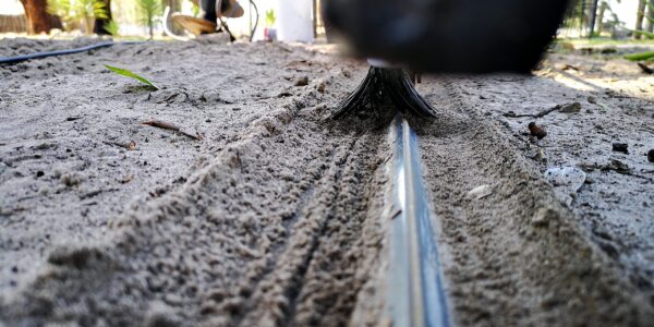 Sliding gate track close-up with Mr. Sweepie® brush kit - for steep driveways where debris washes down, we recommend two sets per gate.
