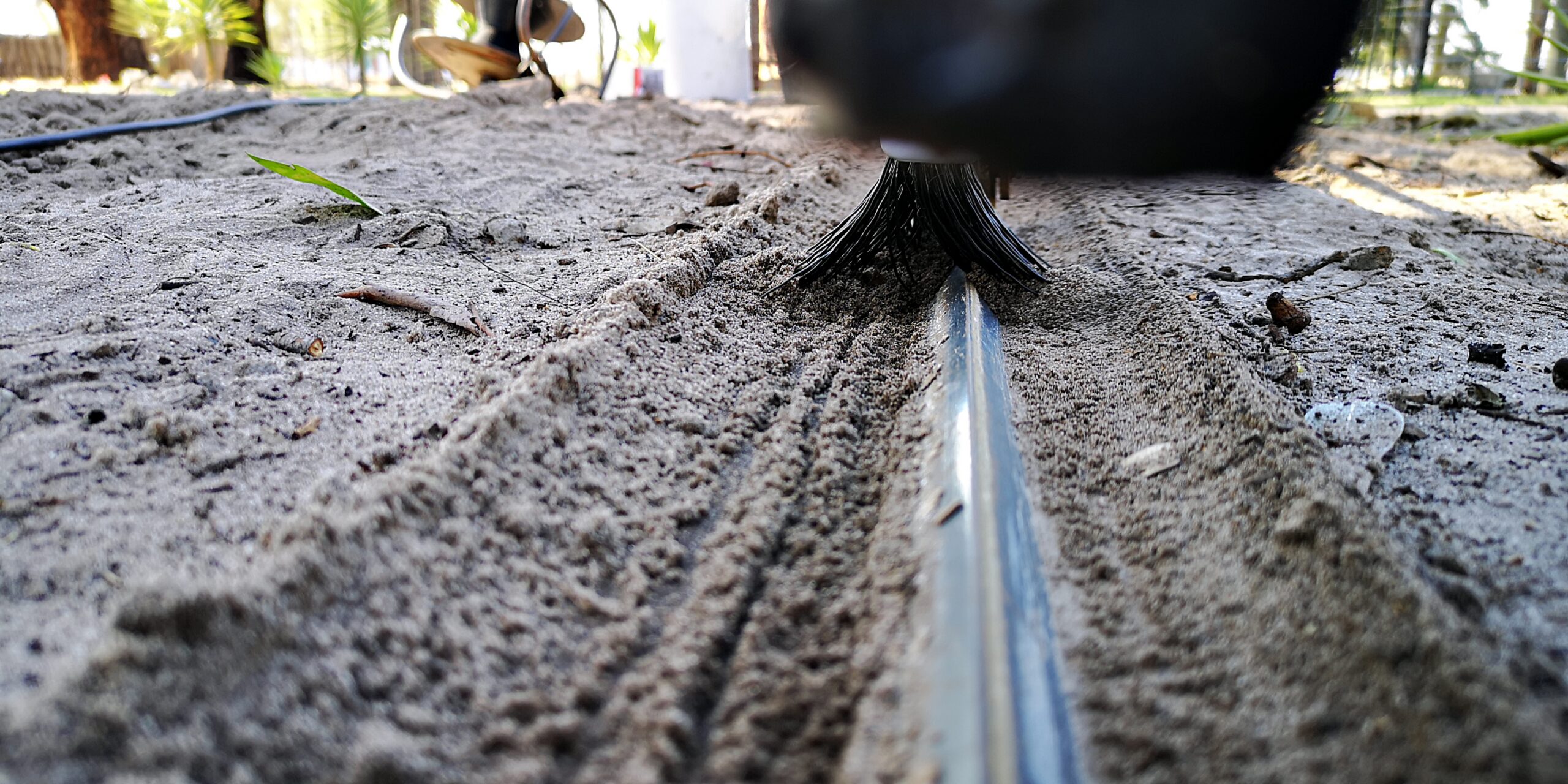 Sliding gate track close-up with Mr. Sweepie® brush kit - for steep driveways where debris washes down, we recommend two sets per gate.